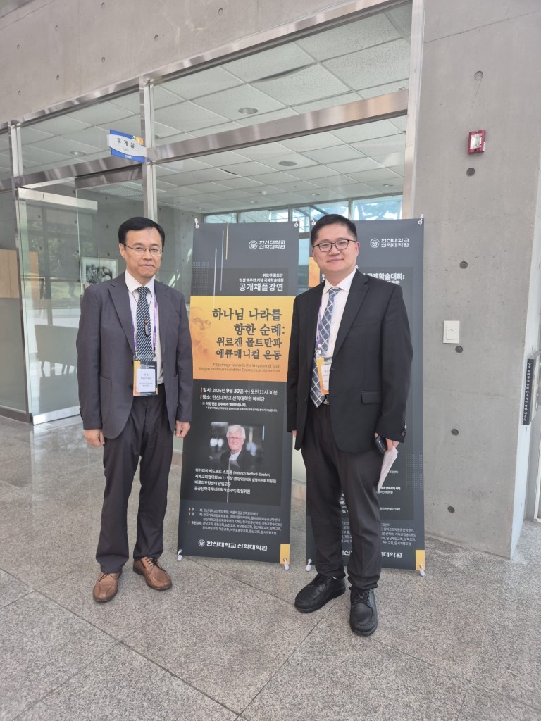 Jacob Chengwei Feng and Prof. Chul Chun standing beside a conference lecture banner at Hanshin University, Seoul